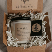 This gorgeous gift set from Grace and Bloom Co, which includes a custom "Will you be my ..." card that doubles as a bookmark, a black matchbox with white-tipped matches, and an 8 oz literary-themed scented soy candle - the perfect way to express your appreciation with a delightfully bookish and memorable bridesmaid proposal.