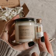 Give the gift of coziness with a boxed birthday gift from Grace and Bloom Co! It includes a small candle in a literary book inspired scent and a glass cork-topped bottle of matches. A card that says Happy Birthday in a vintage botanical style is attached to the inside cover of the box. It can be removed and used as a bookmark.