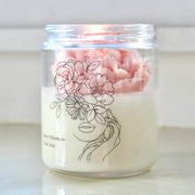 Bring the beauty of the outdoors into your home with a lovely flower candle in a fresh scent! The gorgeous peach-colored wax flower nestled inside and the whimsical hand-drawn flower lady on the label will elevate your decor with a bit of a cottagecore aesthetic