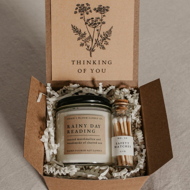 A cozy gift box from Grace and Bloom is perfect for bookish friends, has a candle in your choice of literary scents, a glass bottle of matches, and has a removable kraft-colored card with a floral design and your choice of messages on it. 