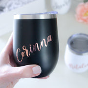 A great gift for bridesmaid proposals or baby shower gifts, your choice of a matte black or matte white insulated wine tumbler with personalized writing on the front: a name or short phrase will be hand-lettered by our lettering artist and applied to the mug in foil vinyl letters.